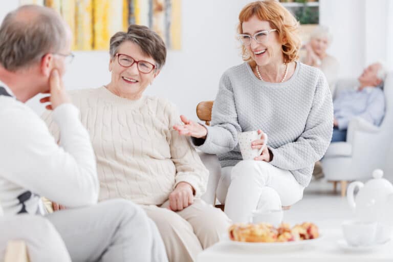 Three senior friends chat and enjoy coffee at the best Concord senior living community
