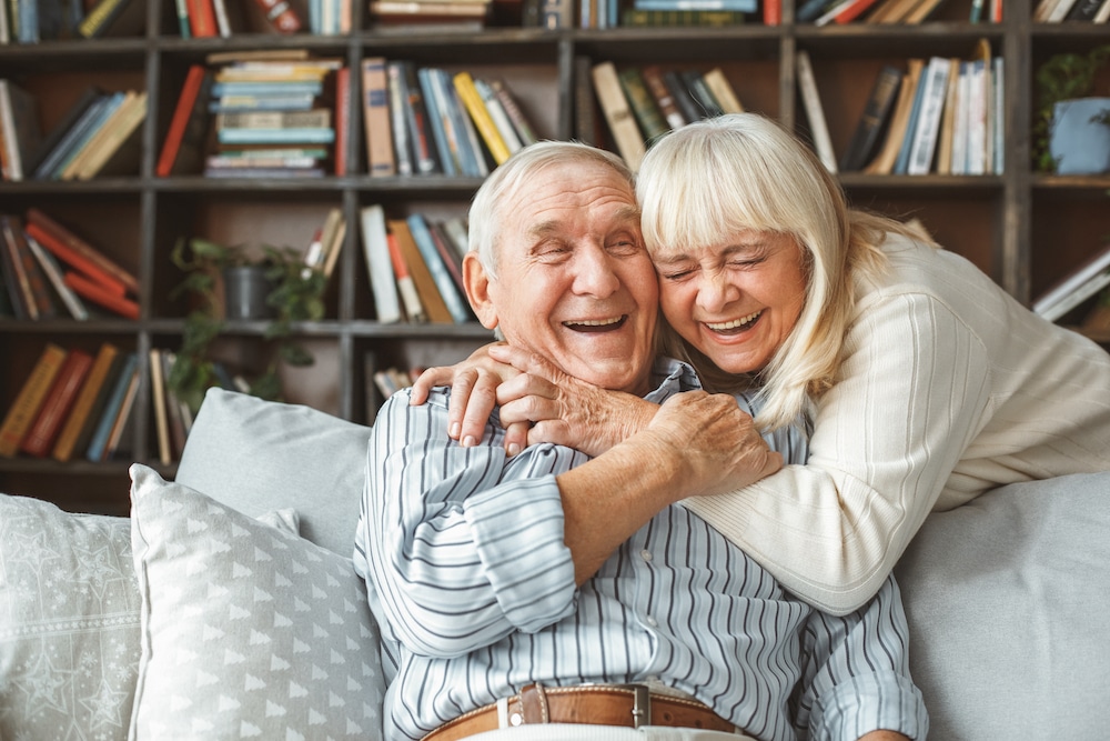 A cheerful senior couple hugging and laughing