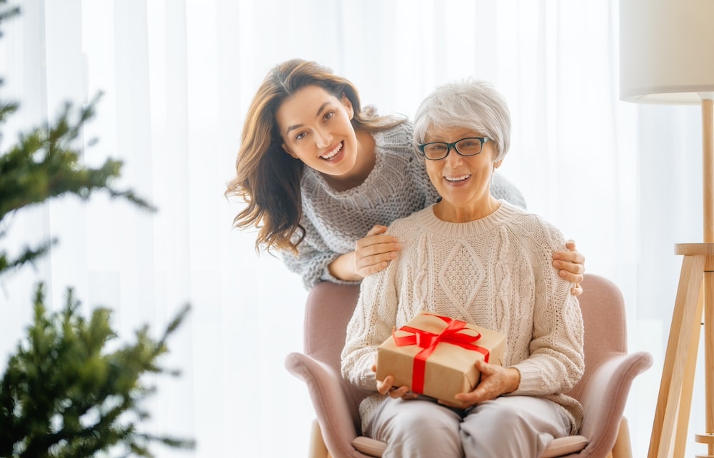 A senior woman holding a holiday gift
