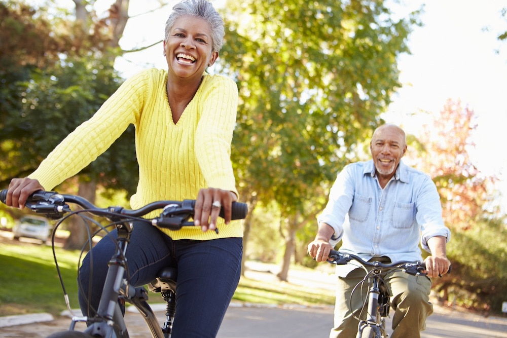 A senior couple riding bikes around outside